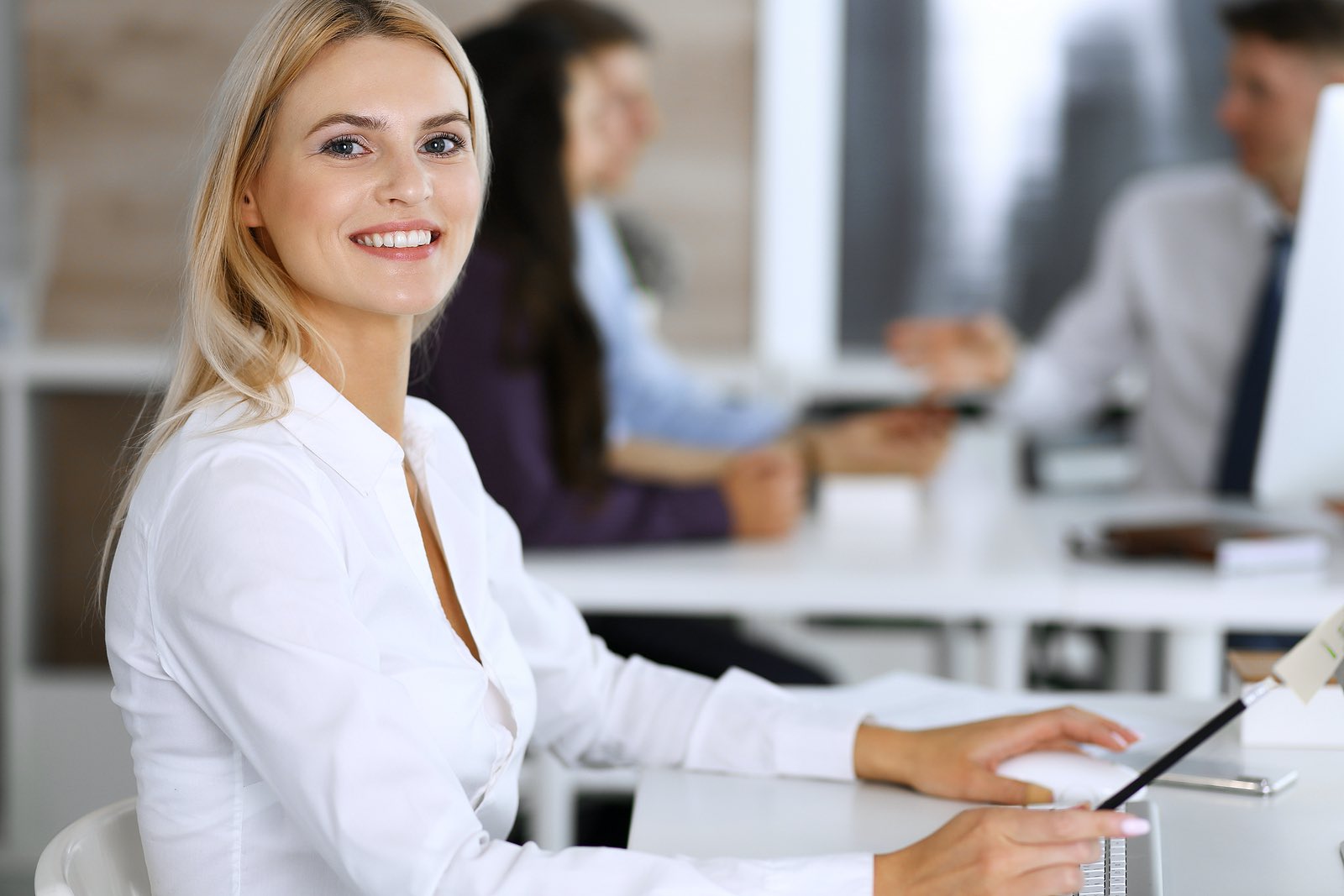 Business woman using computer at workplace in modern office.